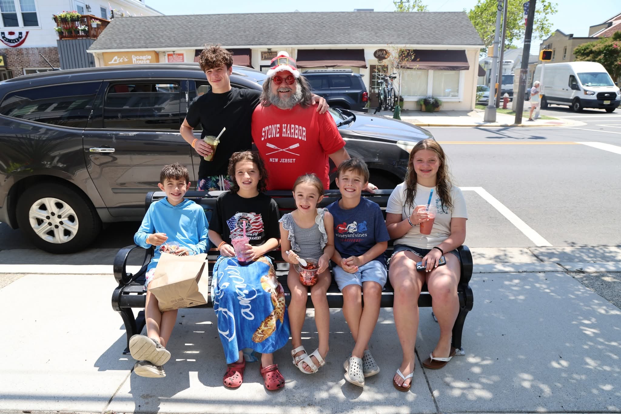 Cape May County Santa with a teenage boy and five kids on a bench outside Lee's Hoagie House