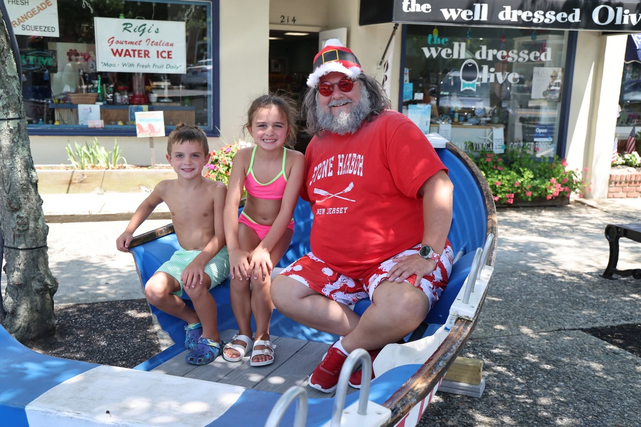 Cape May County Santa with a boy in swim trunks and a girl in a pink bikini in the Stone Harbor boat
