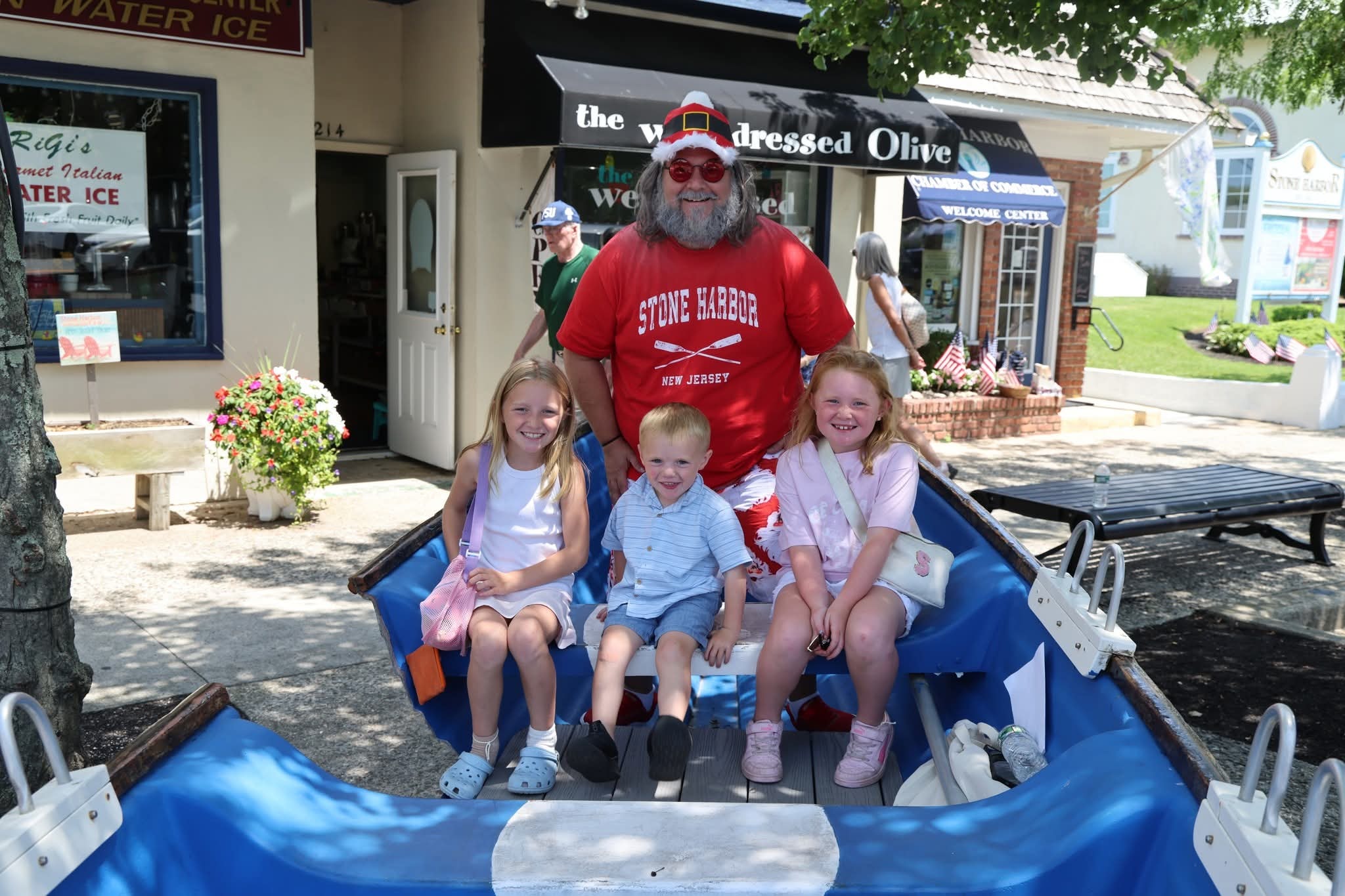 Cape May County Santa with two girls and a toddler boy in the Stone Harbor boat near the Welcome Center