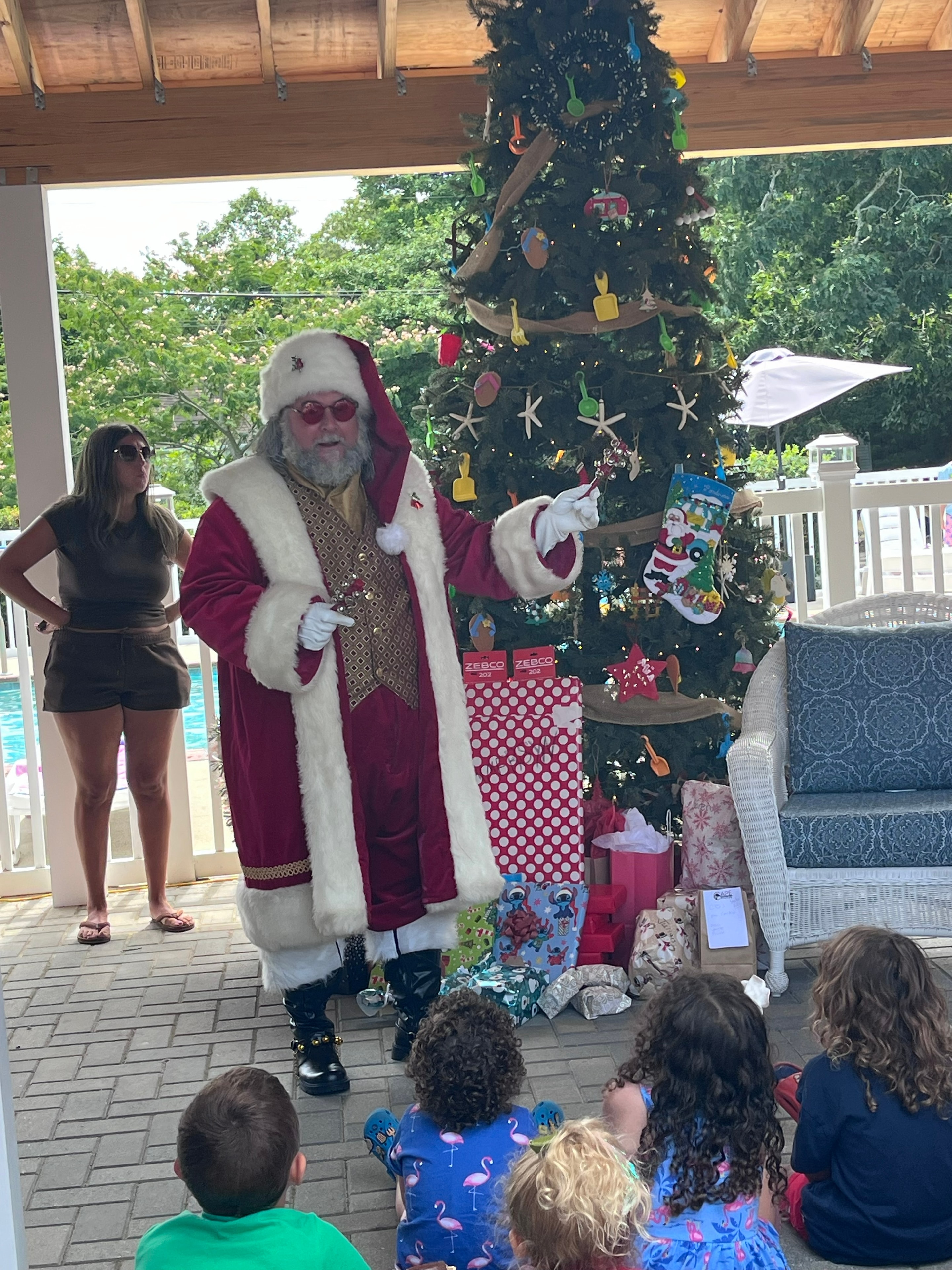 Cape May County Santa reading from his list for children seated on a patio at a campground Christmas event