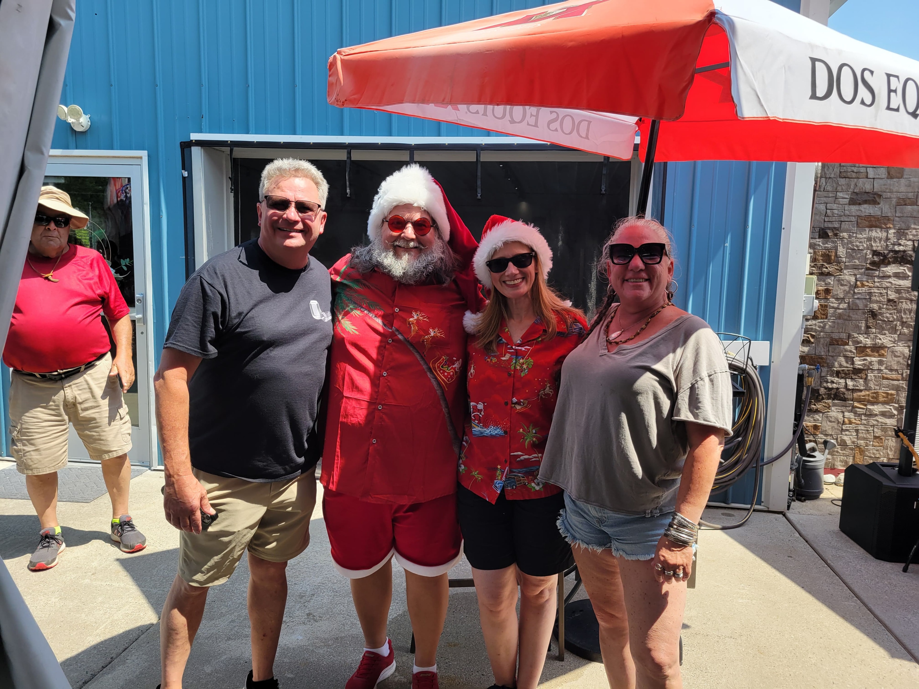 Group of people at an outdoor bar patio event under a red awning