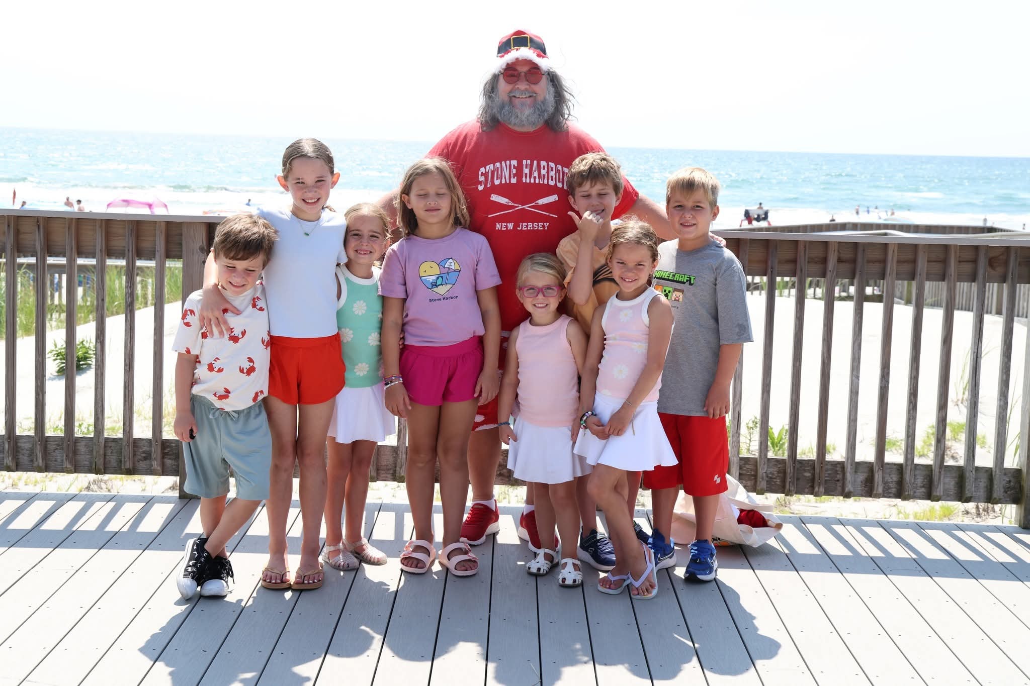 Cape May County Santa surrounded by eight kids on the Stone Harbor boardwalk