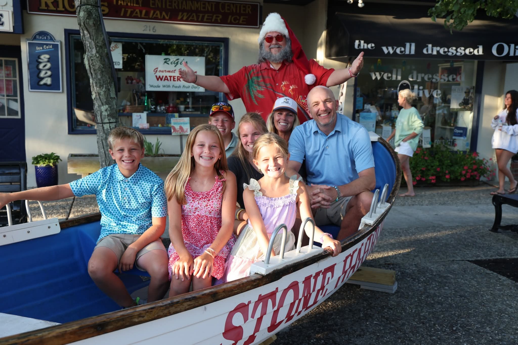 Cape May County Santa with arms wide open behind a family of six in the Stone Harbor boat
