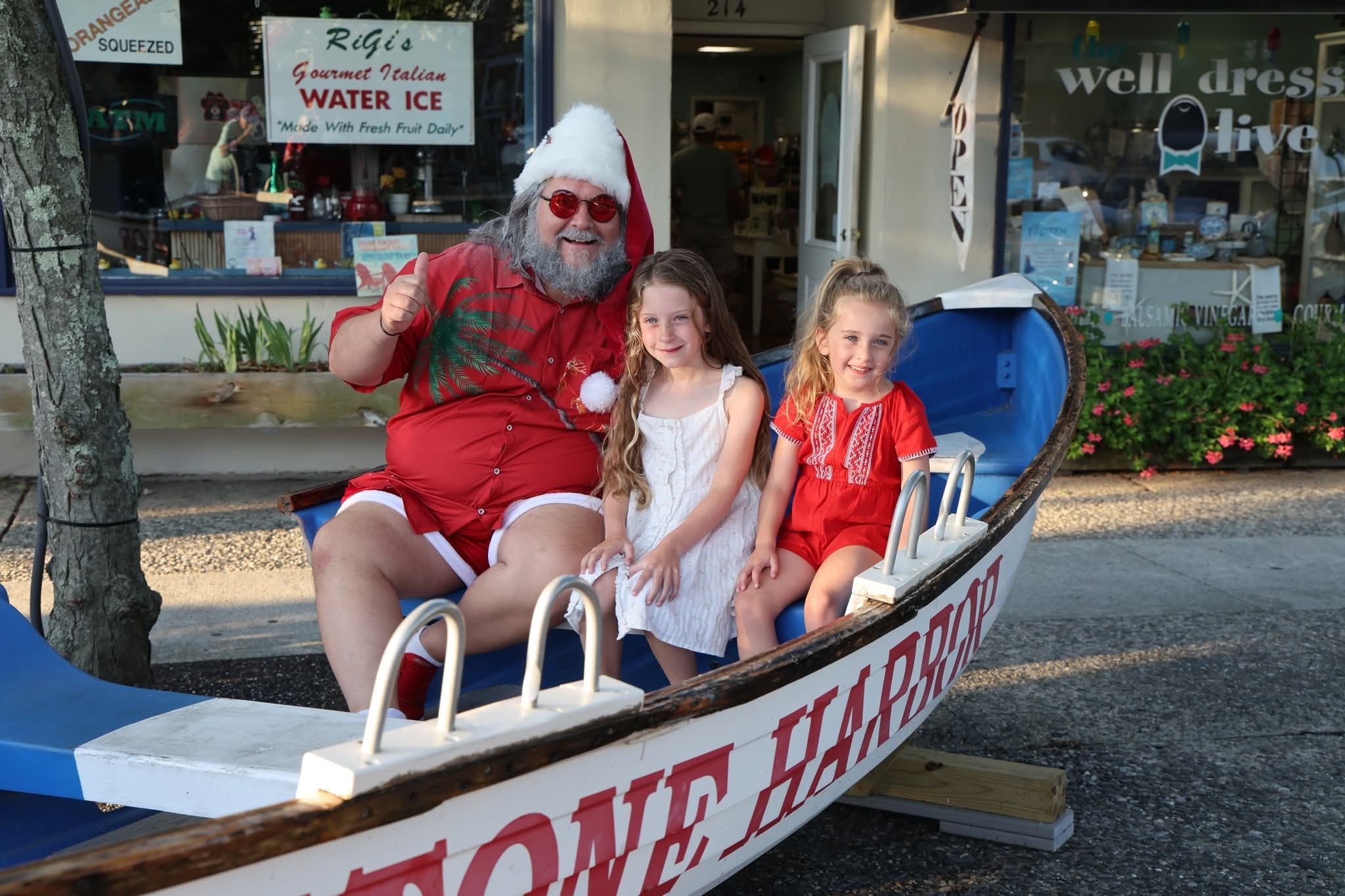Cape May County Santa giving a thumbs up with two girls in the Stone Harbor boat