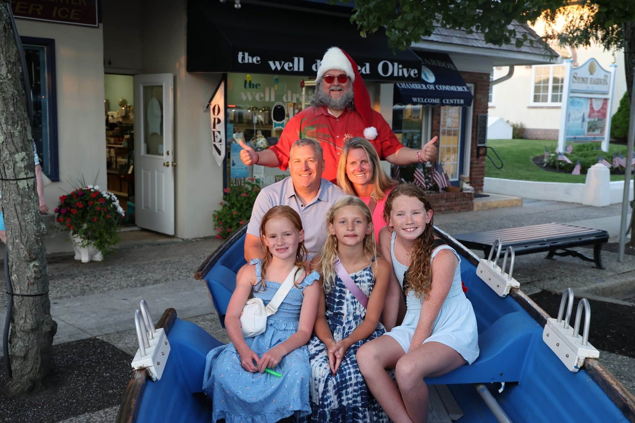 Cape May County Santa with double thumbs up behind a family of five in the Stone Harbor boat