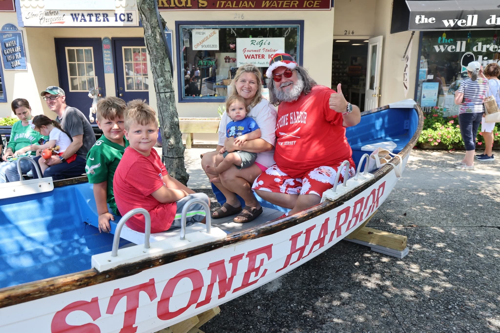 Cape May County Santa with a mom and three boys in the Stone Harbor boat, RiGi's Water Ice in background