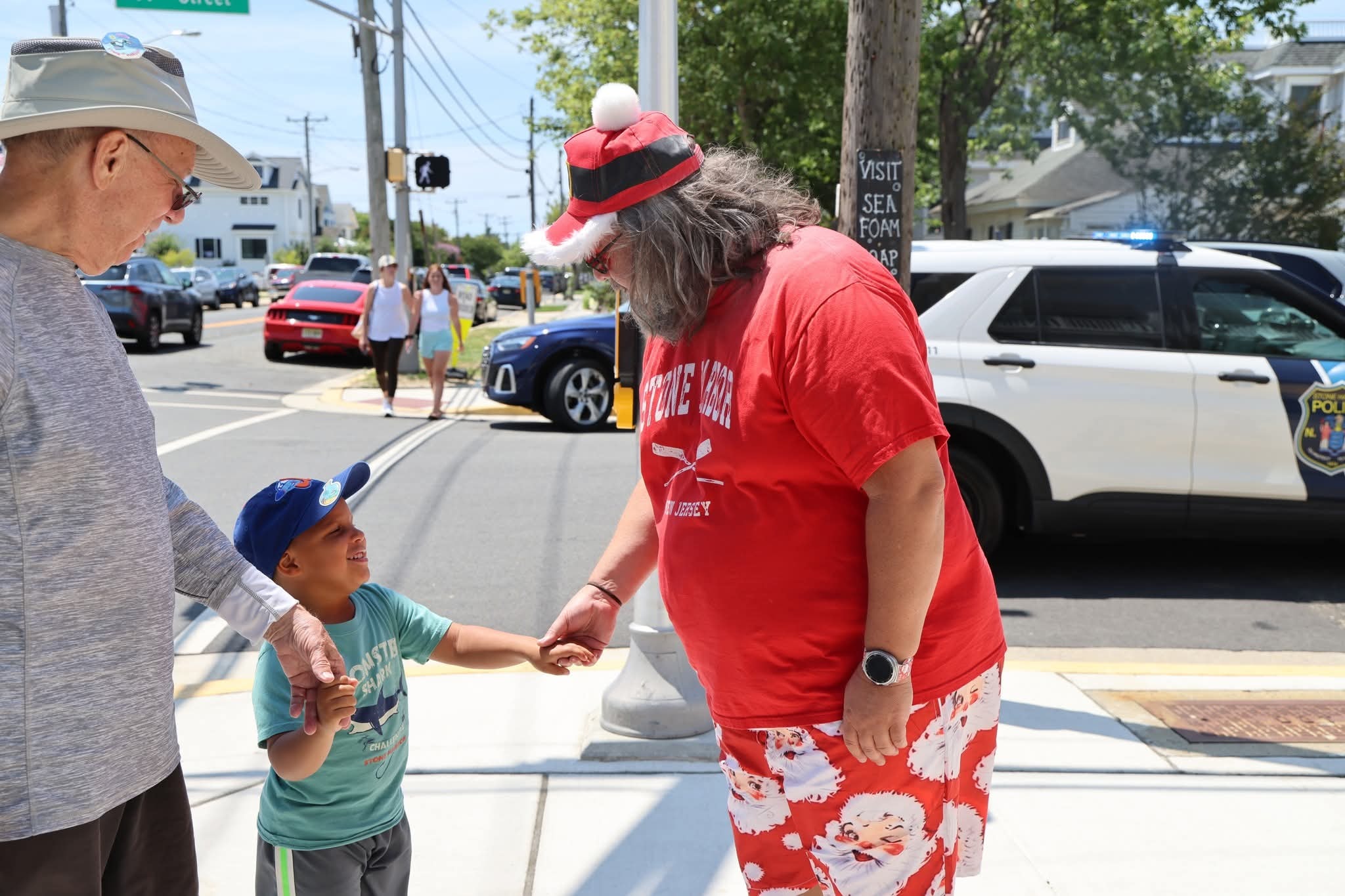 Cape May County Santa and a grandfather watching a little boy shake Santa's hand on the Stone Harbor street